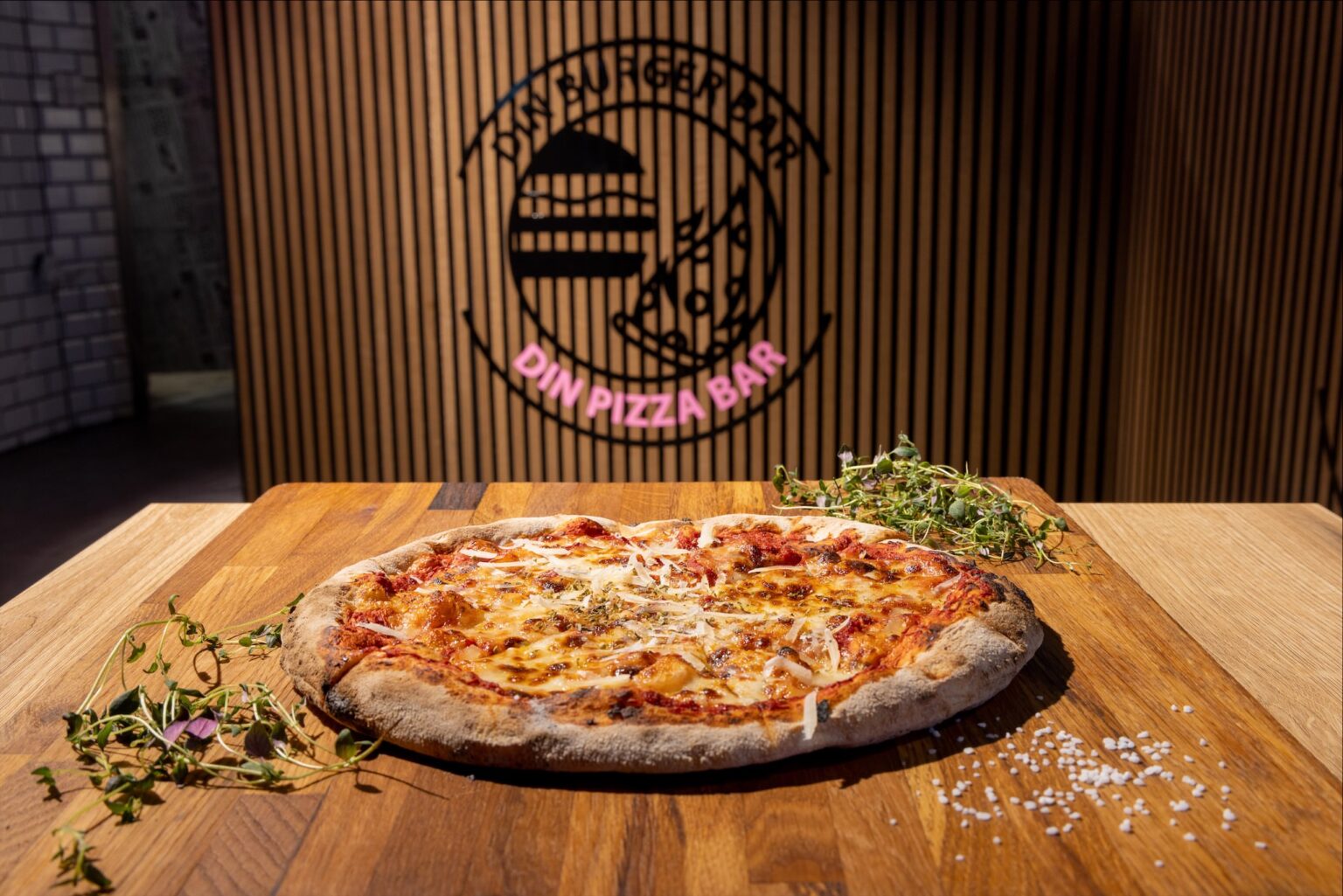 Lækker pizza på træbord i pizzabar.