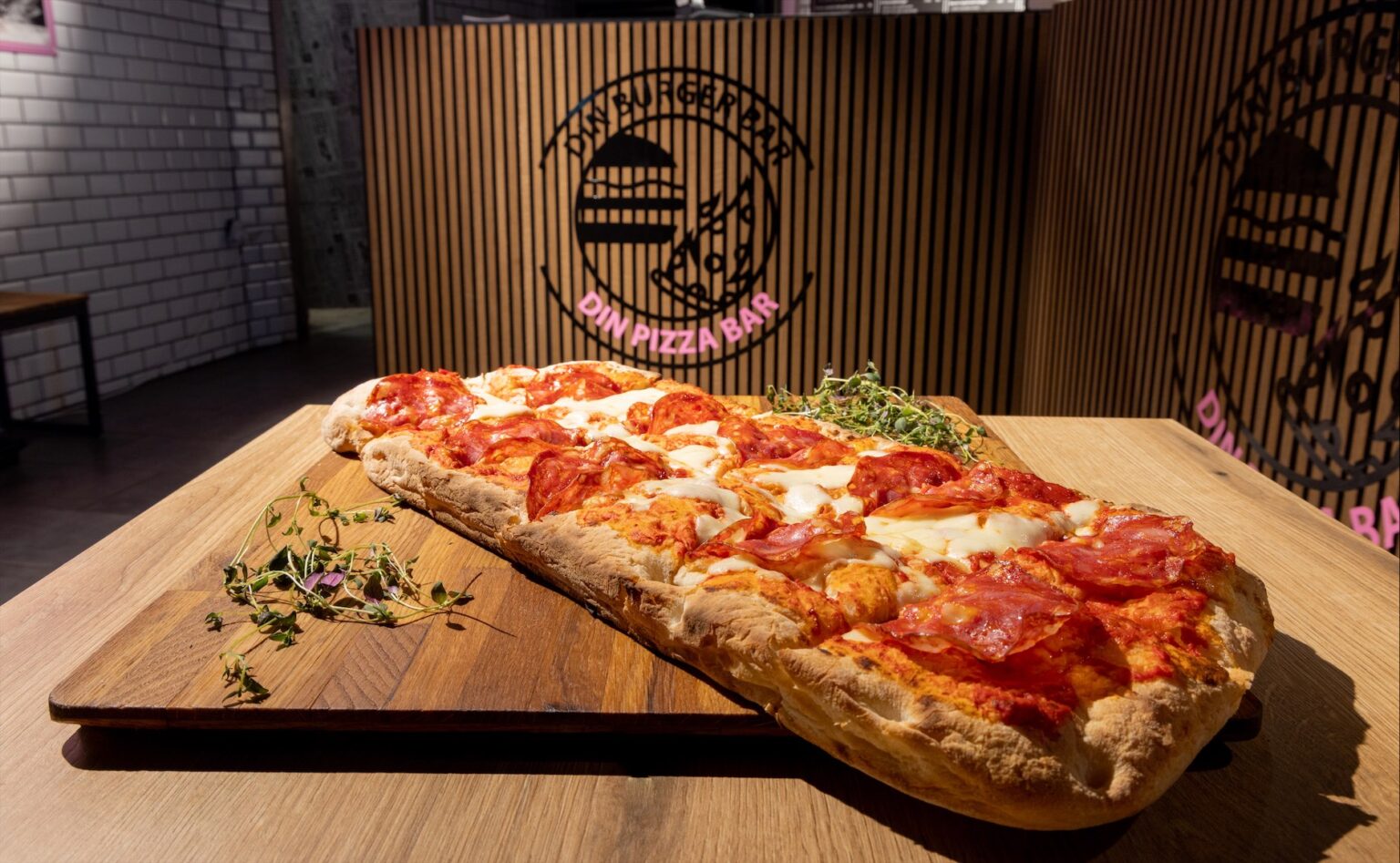 Pizza med tomat og skinke på træplade