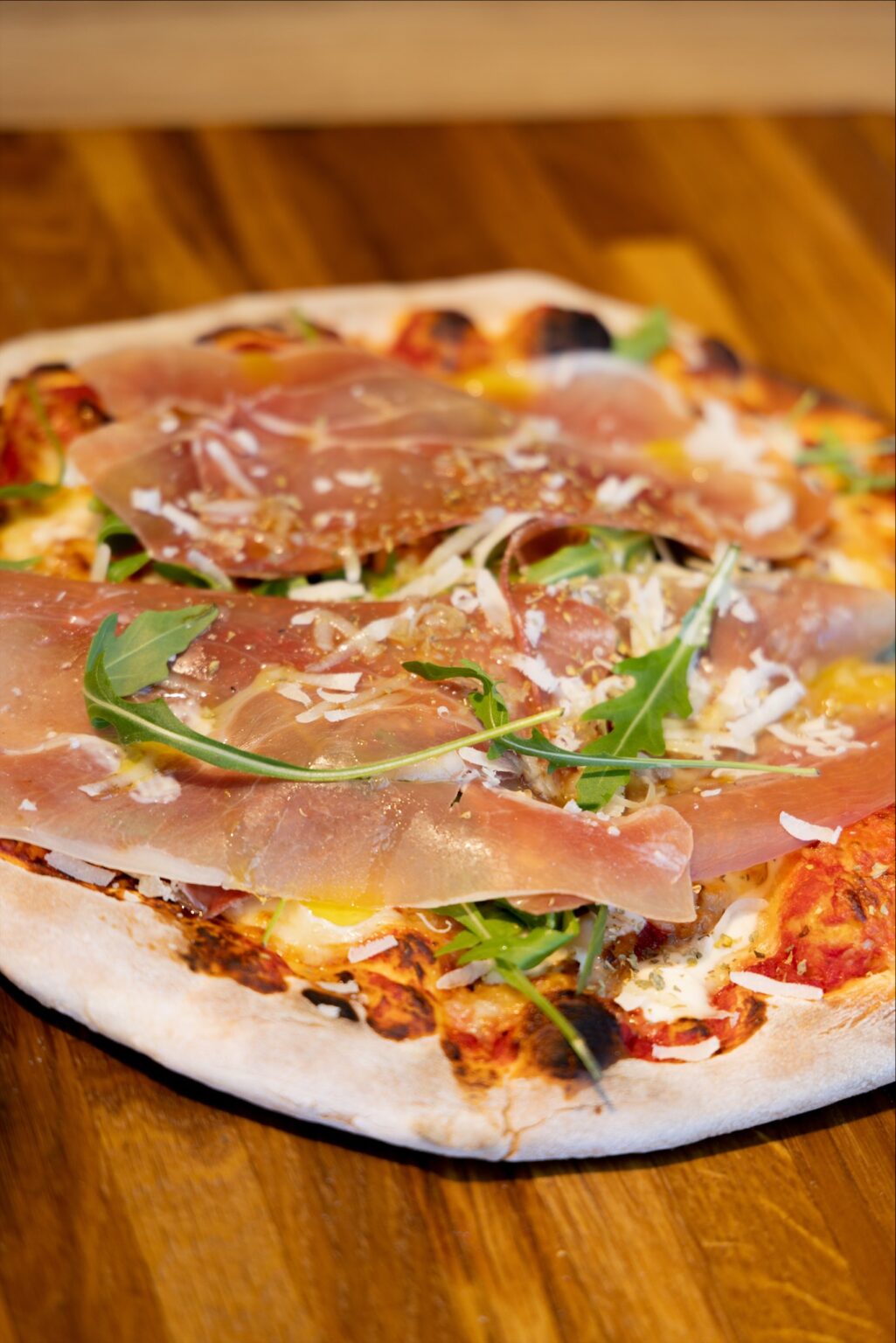 Pizza med parmaskinke, rucola og revet ost